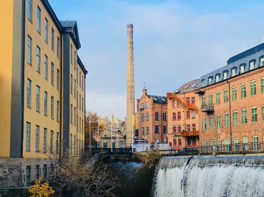 Das Bild zeigt verschiedene Gebäude und einen Turm, der zu einem Industrieunternehmen. Es soll die Standortattraktivität, die durch die Nutzung der Graue-Flecken-Förderung erhöht werden kann, symbolisieren.