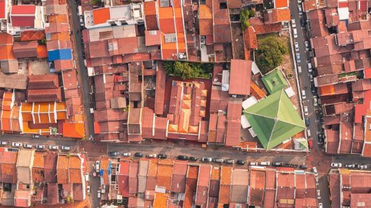 Luftaufnahme einer dicht bebauten Stadt mit eng aneinanderliegenden Häusern und Straßen – symbolisiert das komplexe Versorgungsgebiet für die Netzplanung.