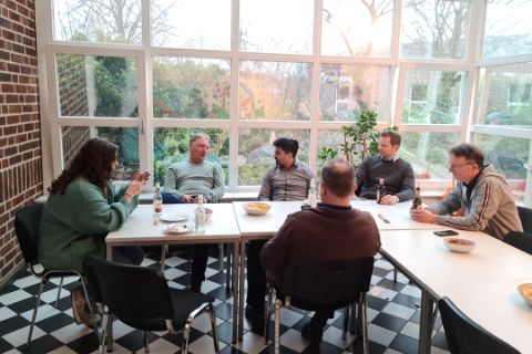 WiR Mitarbeitende in der Küche beim Pizzaessen