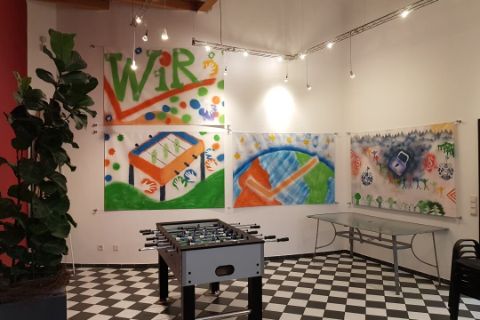 Kickertisch im Aufenthaltsraum mit bunt gestalteten Wandbehängungen im Hintergrund